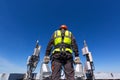 Telecommunication engineer in helmet and uniform holds telecomunication equipment in his hand and antennas of GSM DCS