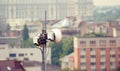 Telecommunication microwave antenna dish on a building rooftop with the city in background