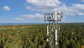 Telecommunication tower with antennas for 5g network on forest and blue sky background. mobile internet broadcast