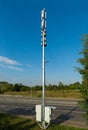 Telecommunication tower with two boxes with computer equipment and road in the background Royalty Free Stock Photo