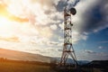 Telecommunication tower with dish and mobile antenna on mountains at sunset sky background Royalty Free Stock Photo