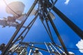 Inside view of telecommunication tower with microwave, radio antennas and cables against blue sky and sun. Inside view. Royalty Free Stock Photo