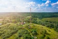 Telecommunication tower with radio antennas and satellite dishes is installed on the rural on the green field with gras Royalty Free Stock Photo