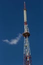 Telecommunication tower with radio, microwave and television antenna system located in the forest against the blue sky. Antenna Royalty Free Stock Photo