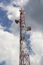Telecommunication tower with radio, microwave and television antenna system located in the forest against the blue sky. Antenna Royalty Free Stock Photo