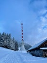 Telecommunication tower and wooden hut on mountain top in winter at sunset. Duenser Aelpele, Vorarlberg, Austria. Royalty Free Stock Photo