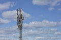 Cellular antennas on a metal mast against a blue cloudy sky Royalty Free Stock Photo