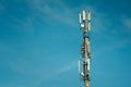 Telecommunications mast set against blue sky and big white cloud Royalty Free Stock Photo