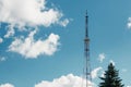 Telecommunications mast set against blue sky and big white cloud Royalty Free Stock Photo