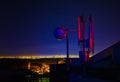 Telecommunications tower, antenna and satellite dish and city at night as background Royalty Free Stock Photo