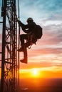 Telecommunications tower climber at sunset, showcasing skilled worker ascending structure against vibrant sky Royalty Free Stock Photo