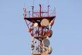 Telecommunications tower and satellite dish telecom network on blue sky with bright sun light Royalty Free Stock Photo