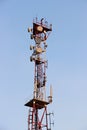 Telecommunications tower and satellite dish telecom network on blue sky with bright sun light Royalty Free Stock Photo