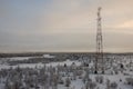 Telecommunications tower and satellite dish telecom network on evening sky with sundown and winter north forest Royalty Free Stock Photo