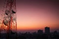 Telecommunications tower and satellite dish telecom network with silhouette of countryside area in sunrise Royalty Free Stock Photo