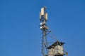 Telecommunications tower with transmitters. Base station with transmitting antennas on a telecommunications tower against the blue Royalty Free Stock Photo