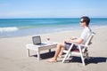 Telecommuting, businessman with laptop on the beach Royalty Free Stock Photo