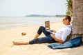 Telecommuting, businessman relaxing on the beach with laptop and palm, freelancer workplace, dream job. Royalty Free Stock Photo