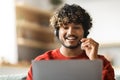 Telecommuting Concept. Young Indian Male Wearing Headset Working On Laptop At Home Royalty Free Stock Photo