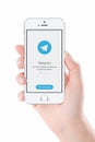 Telegram messenger launch screen on iPhone smartphone display in female hand