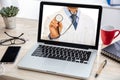 Telemedicine concept. Doctor GP on a computer screen, office desk background