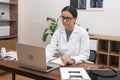 female doctor engages with her laptop to provide medical support and conduct video consultations