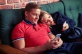 Telephone addiction of young couple on the sofa using telephones