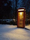 Telephone box on  a snow covered village street Royalty Free Stock Photo