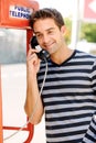 Telephone, happy and man in city by booth for communication, phone call and contact. Fashion, payphone and person in Royalty Free Stock Photo