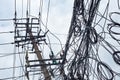 Telephone pole and chaotic mess of wires against sky