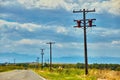 Telephone poles next to road through the desert with mountains in the distance Royalty Free Stock Photo