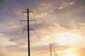 Telephone poles and wires against sky with clouds Royalty Free Stock Photo