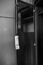 The telephone receiver hangs on a closet in an abandoned house. Black and white photo. Royalty Free Stock Photo