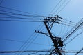 Telephone wires in silhouette against a blue sky