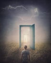 Teleportation doors concept. Rear view of a person standing in front of a doorway in the land, as seen in the mirror like a portal