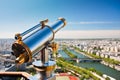 Telescope on the viewpoint with view of the Seine river and its green banks. Panoramic view of Paris in sunny weather.