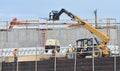 A telescopic construction forklift lifts a compressor