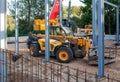 Telescopic handler against the background of a mobile crane at a construction site in the evening after work Royalty Free Stock Photo