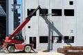 A telescopic handler brings up some steel bars to the first floor of the building under construction