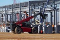 Telescopic handler at work in a large construction site.