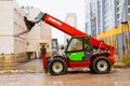 Telescopic loader handler. Red Manitou telehandler at construction site after rain. Side view, lifestyle photo. Astana Nur-Sultan