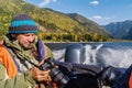 Traveler photographer in a life jacket aboard a motor boat checks the camera settings. Fall