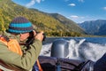 A traveler photographer in a life jacket takes pictures from the side of a motor boat. Fall