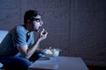 Television addict man on sofa watching TV and eating popcorn in funny nerd geek glasses Royalty Free Stock Photo