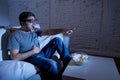 Television addict man on sofa watching TV in funny nerd geek glasses laughing crazy Royalty Free Stock Photo