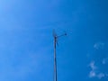 Television antenna standing against blue sky background Royalty Free Stock Photo