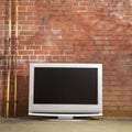 Television by brick wall. Royalty Free Stock Photo