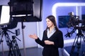 Television presenter recording in news studio.Female journalist anchor presenting business report,recording in television studio Royalty Free Stock Photo