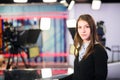 Television presenter recording in news studio.Female journalist anchor presenting business report,recording in television studio Royalty Free Stock Photo