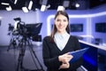 Television presenter recording in news studio.Female journalist anchor presenting business report,recording in television studio Royalty Free Stock Photo